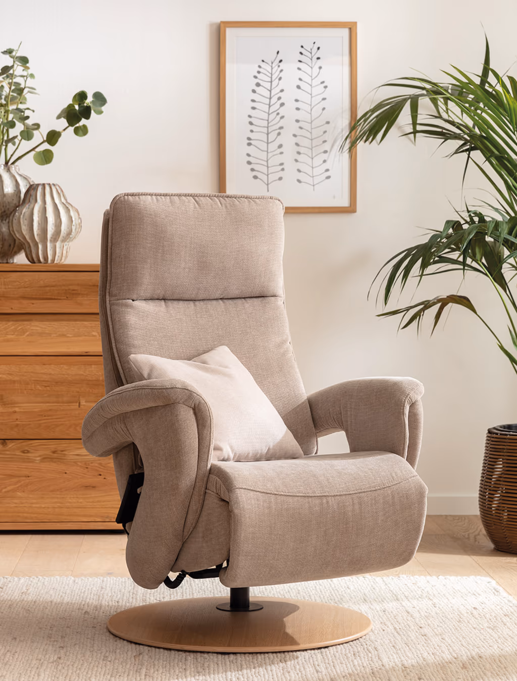 Moderner Relaxsessel in Beige mit rundem Holzfuß und Kissen. Der Polstersessel steht in einem hell eingerichteten Wohnzimmer mit Pflanzen und Deko – ideal für entspanntes Sitzen und Relaxen.